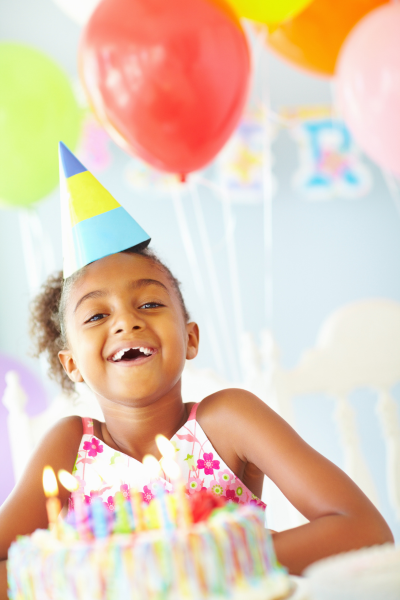 Little girl laughing with birthday cake at Celebrate You
